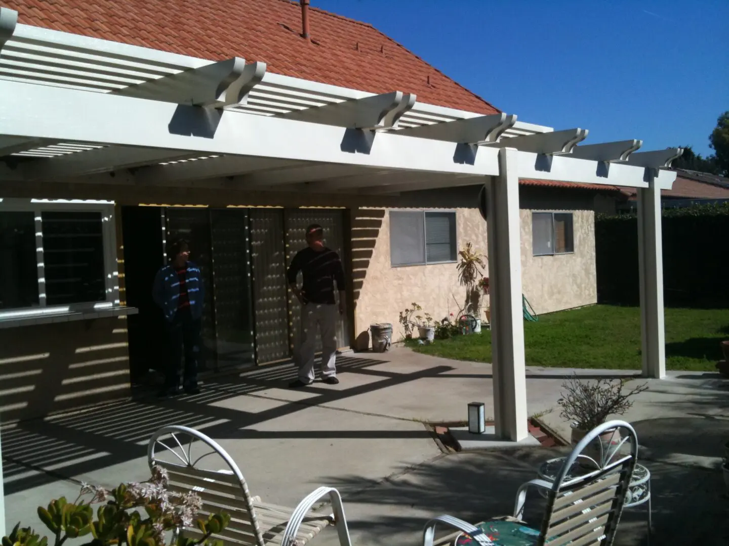 A man standing under an awning on top of a patio.