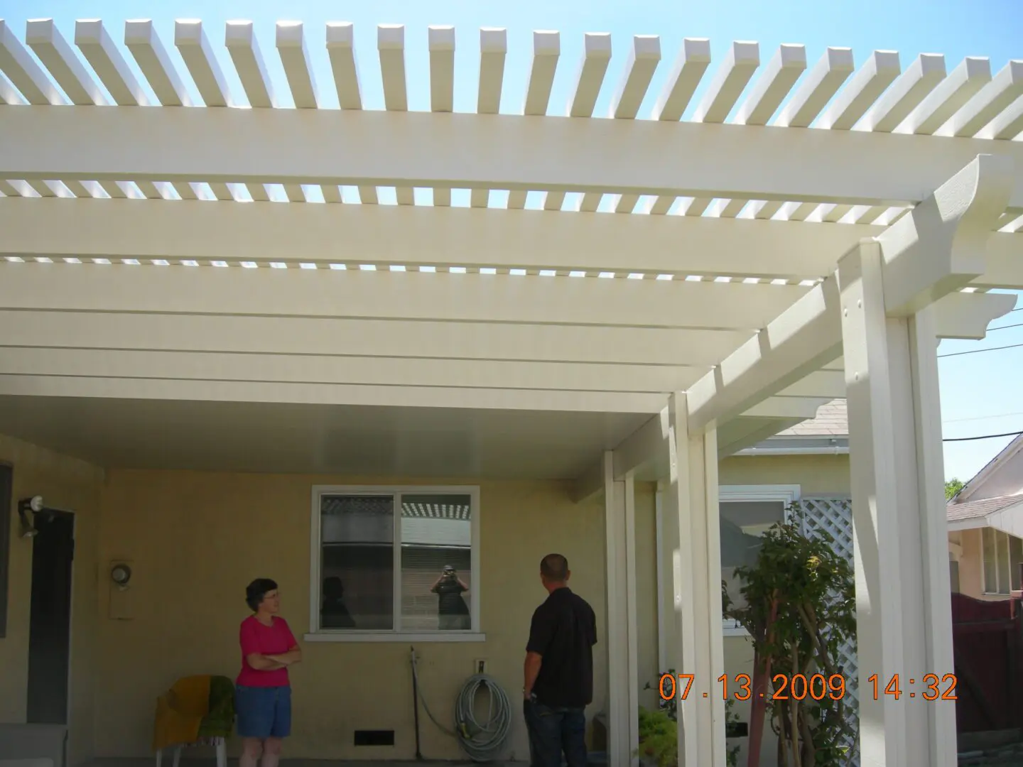 A man and woman standing under an awning.