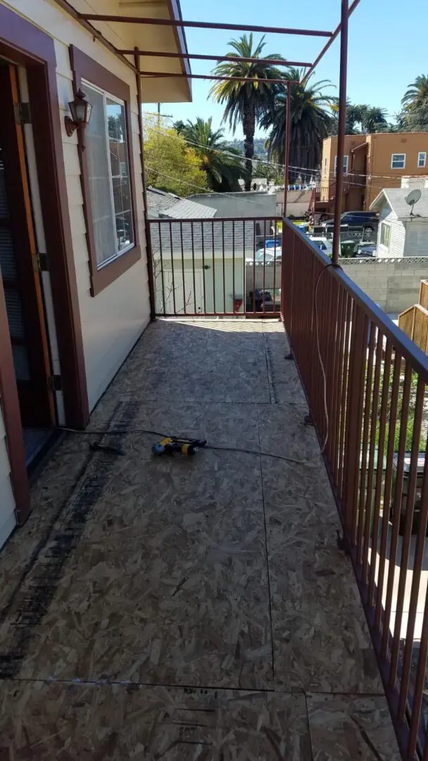 A cat is laying on the ground outside of a house.