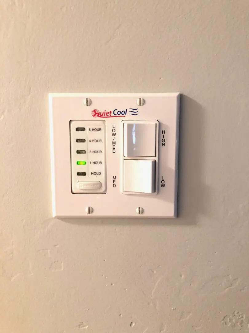 A white wall mounted electrical switch with buttons.