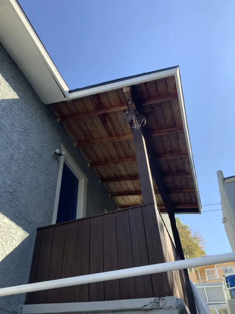 A wooden awning over the entrance of a house.