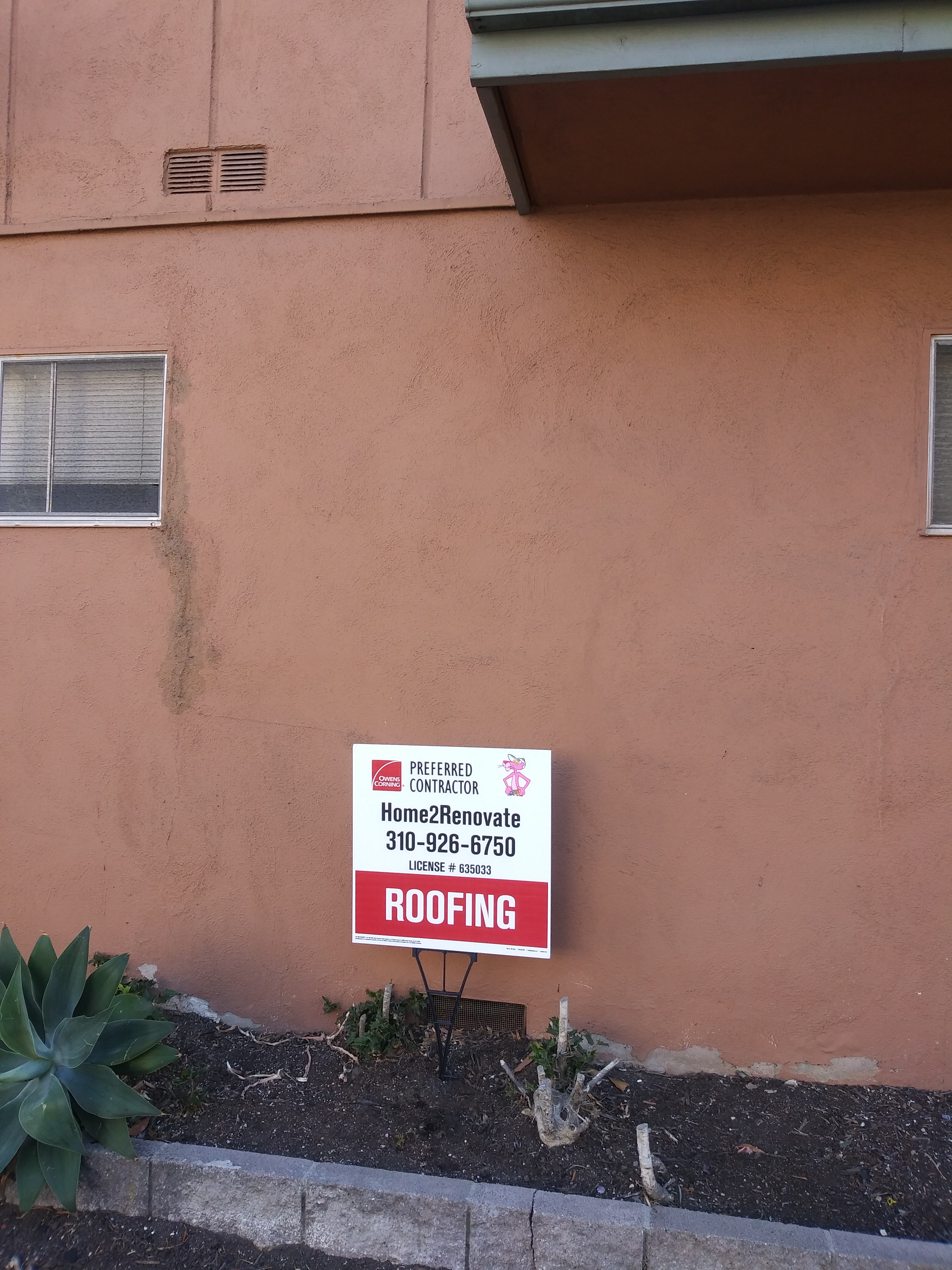 A sign is posted in front of the house.