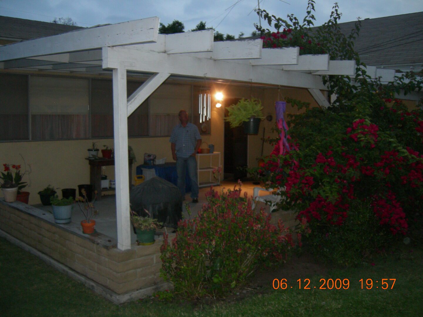 A man standing under an awning in the evening.