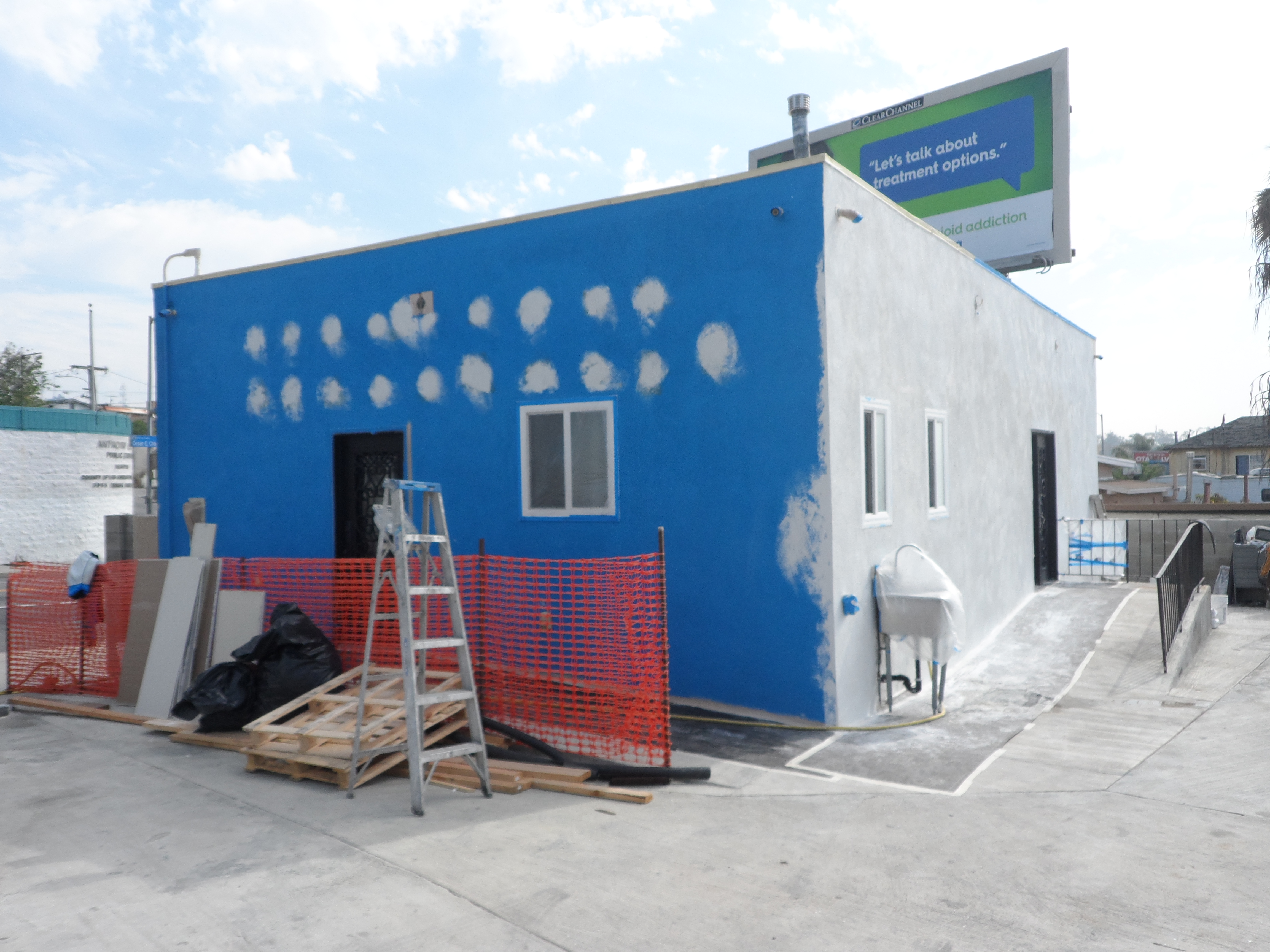 A building being painted with blue and white paint.