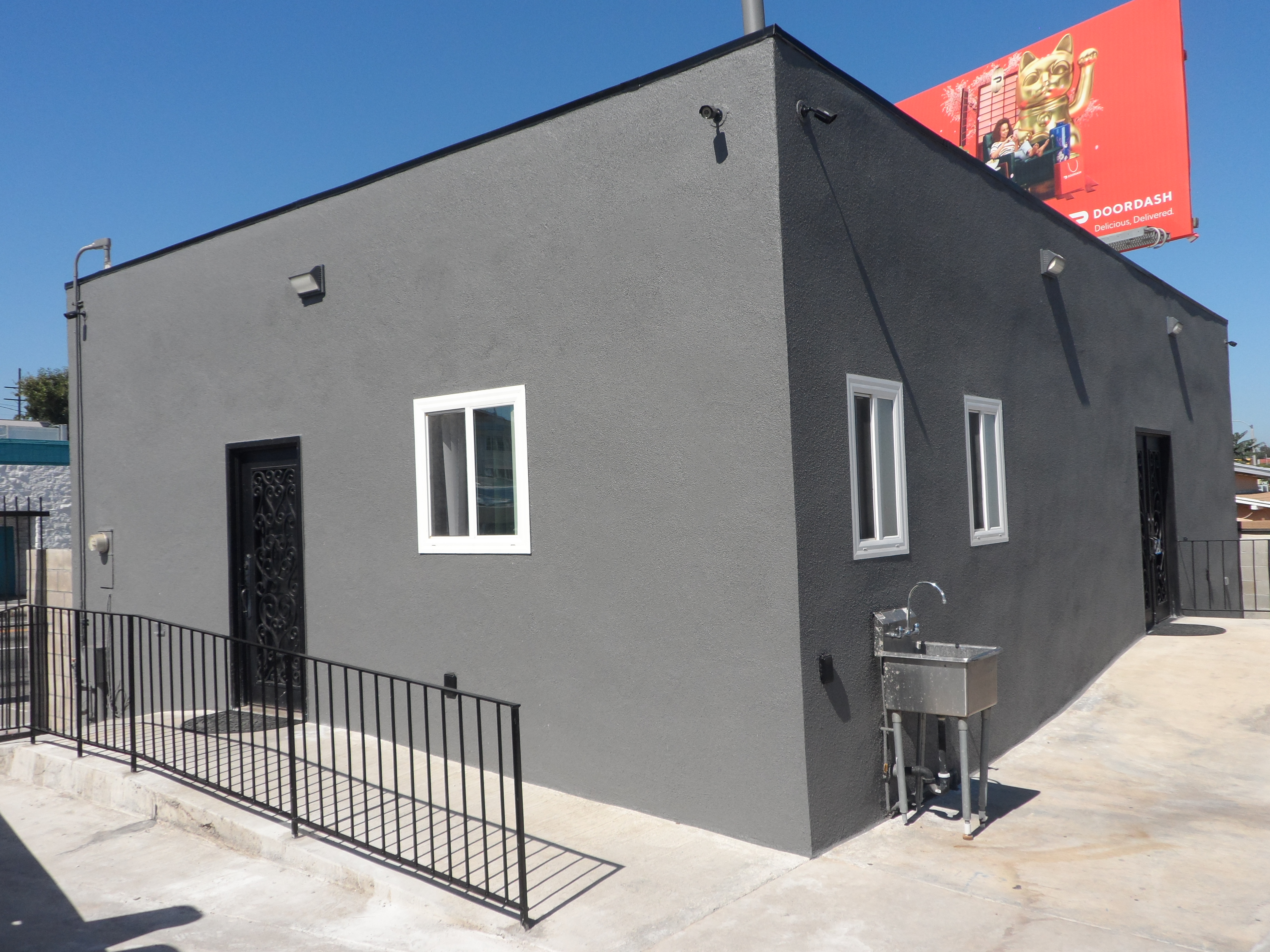 A building with a metal fence and a black gate.