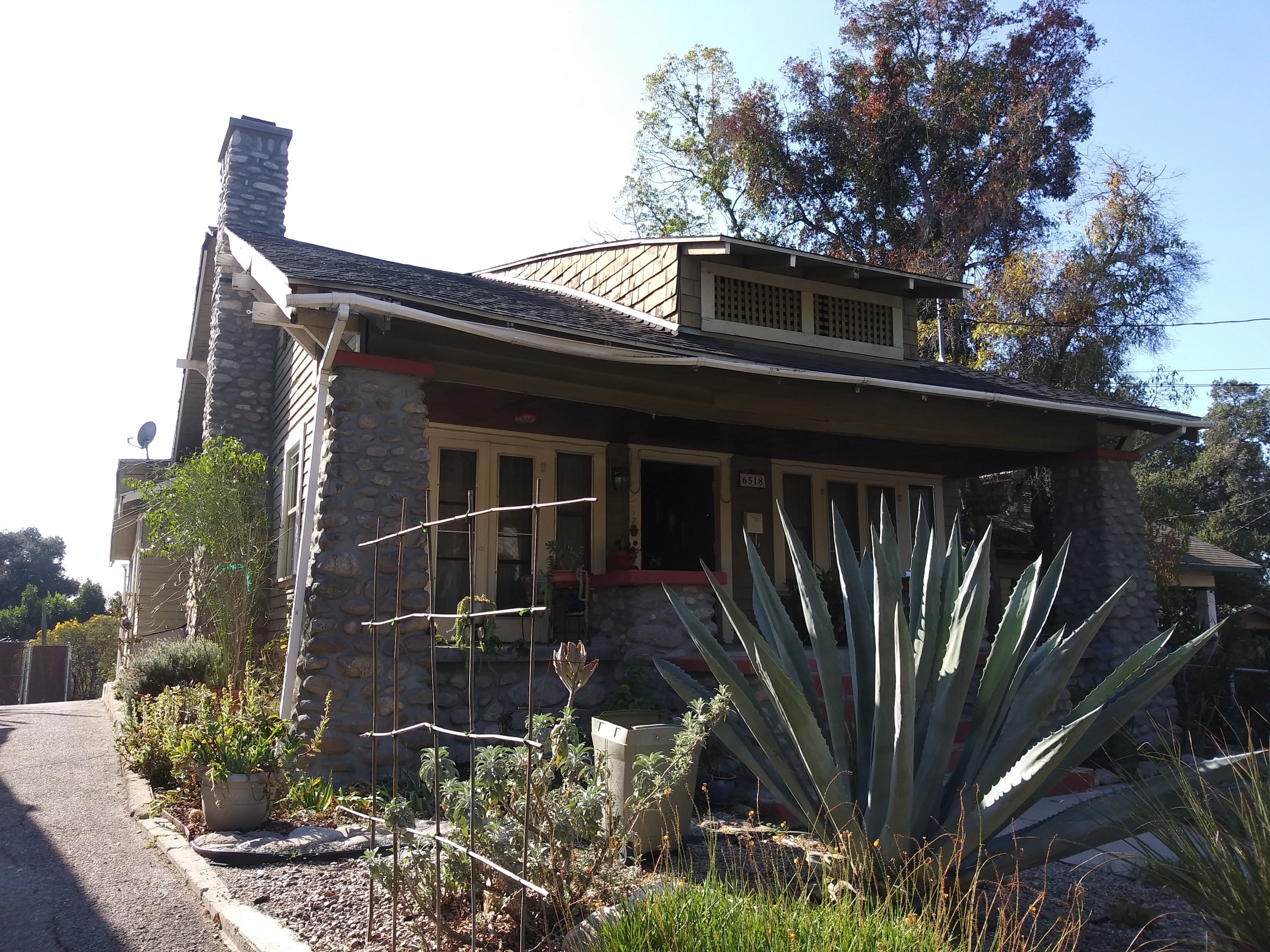 A house with plants and bushes in front of it.