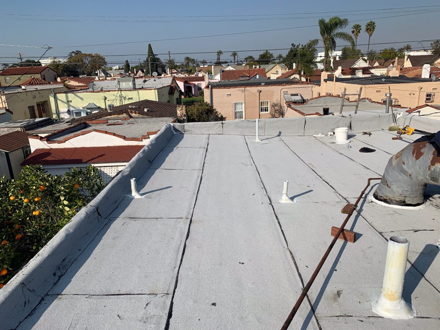 A roof that has been painted white and is being cleaned.