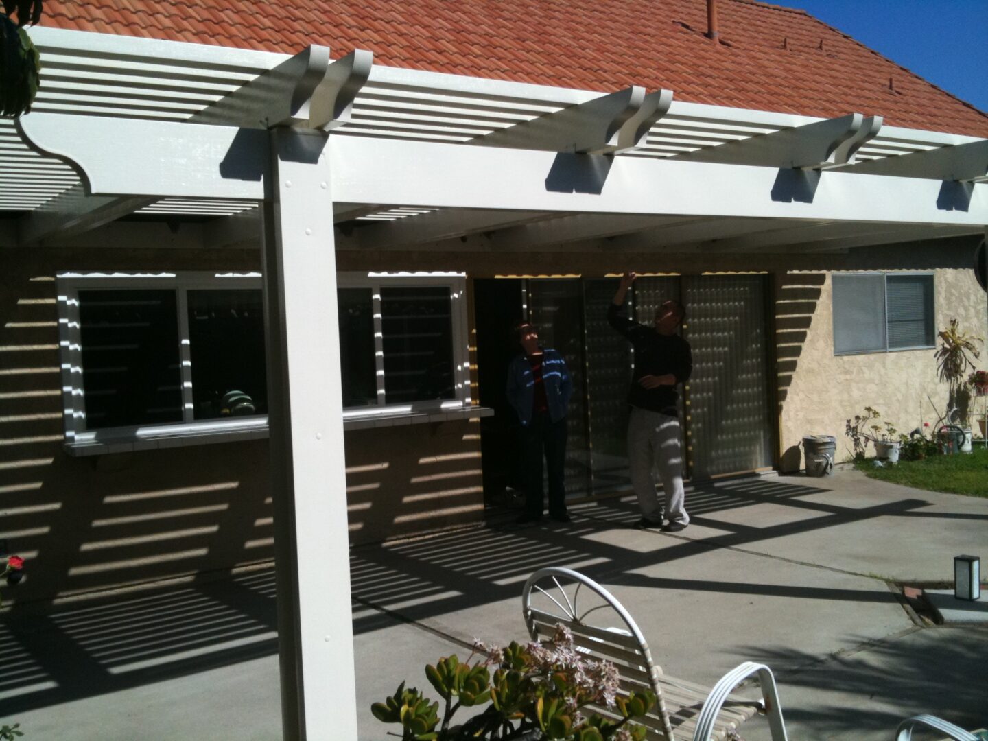 A couple of people standing under an awning.