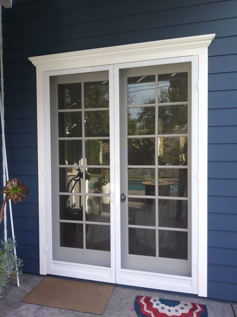 A white door with two windows on the outside of a house.