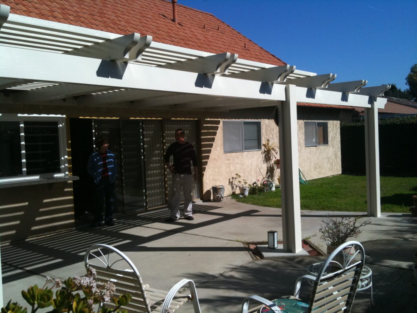 A man standing under an awning on top of a patio.