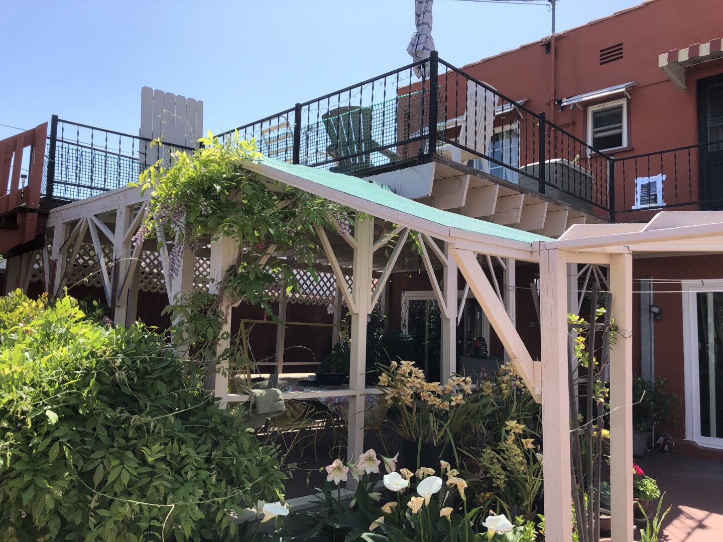 A patio with flowers and plants in the foreground.