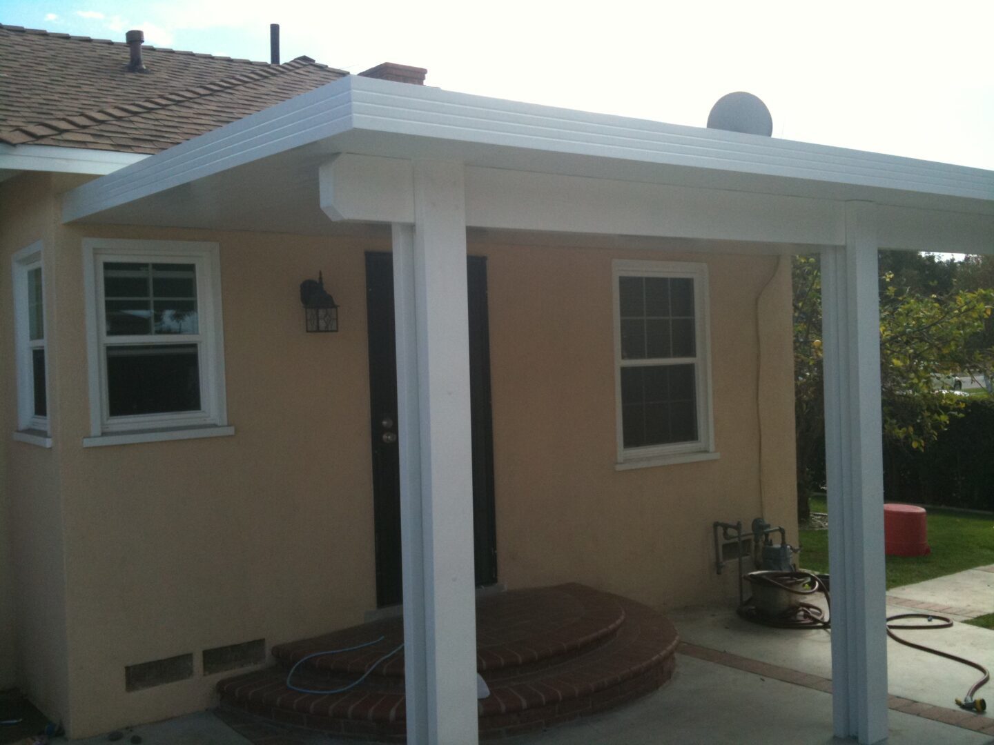 A white covered patio with two dogs in it.