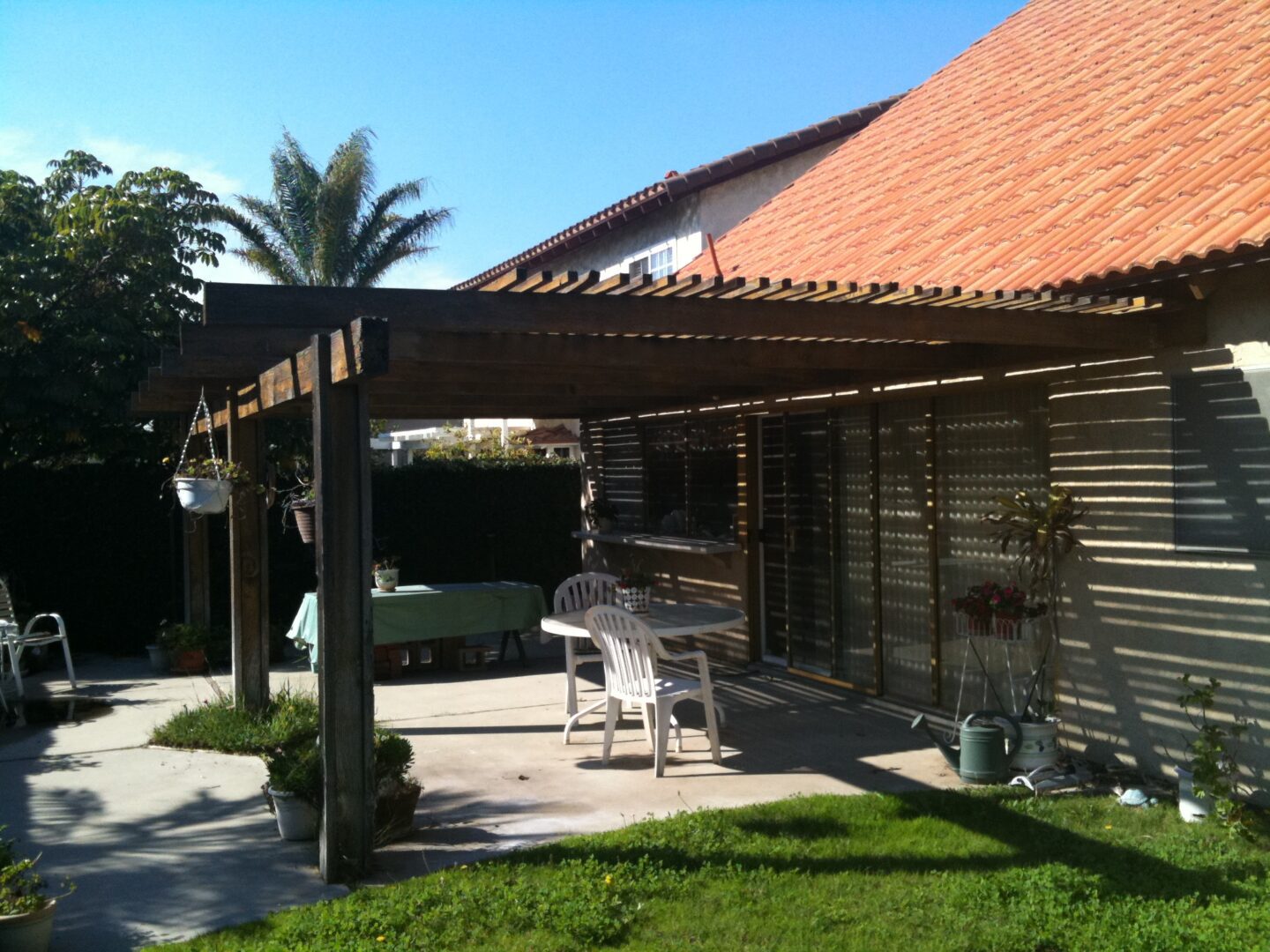 A patio with a table and chairs under an awning.