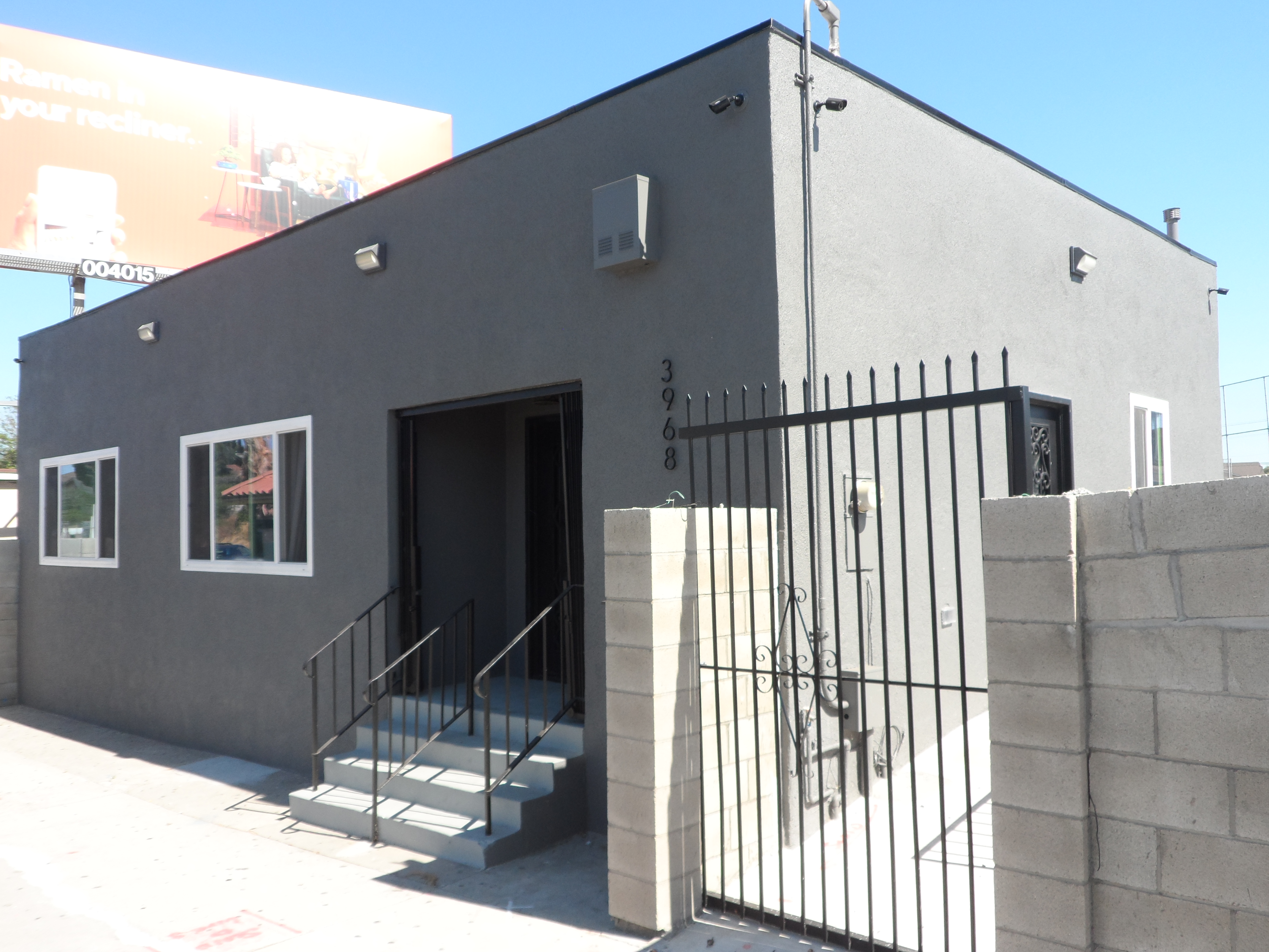 A building with a metal fence and steps leading to it.