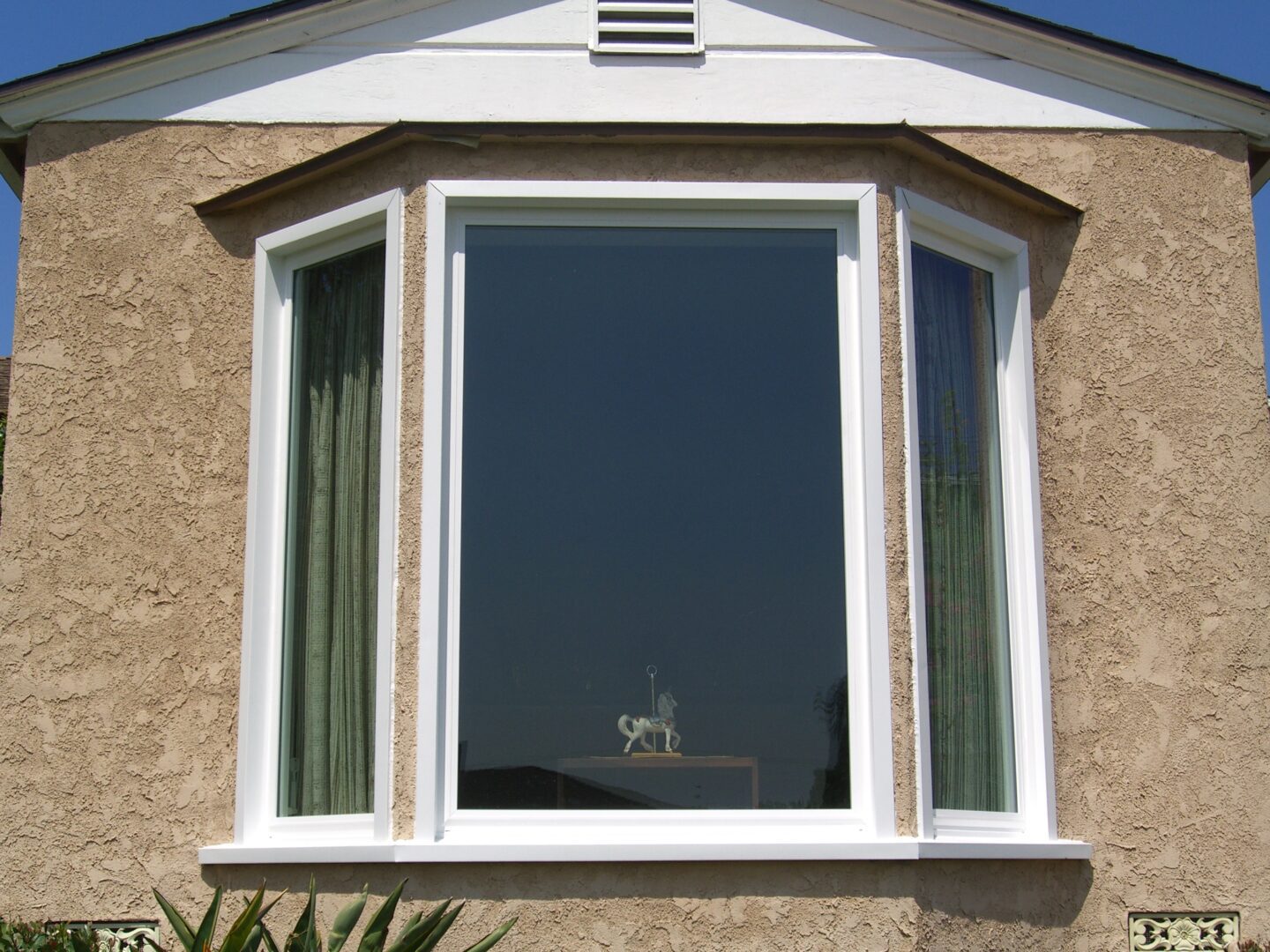 A window with a dog sitting in the middle of it.