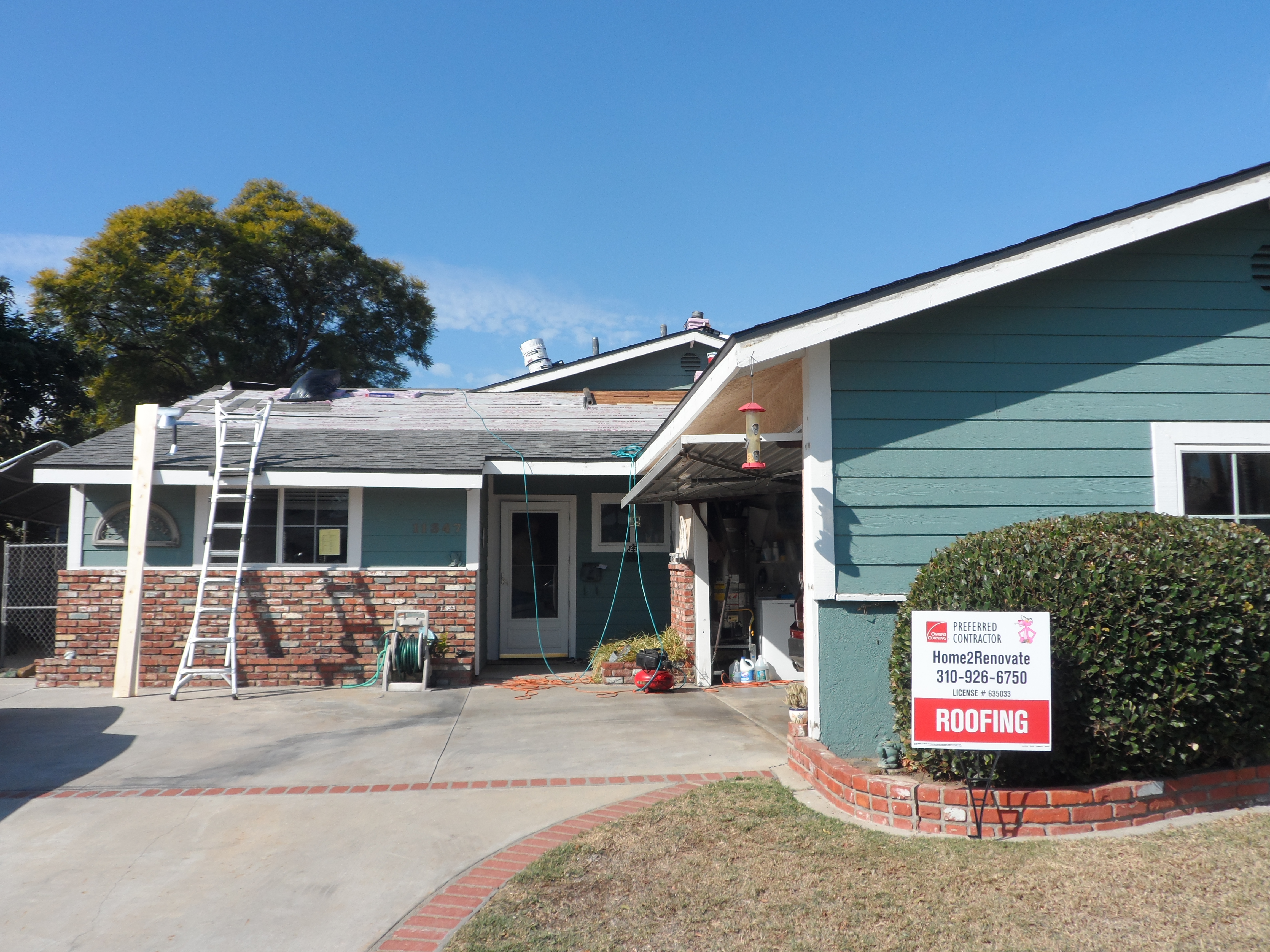 A house with a ladder and sign in front of it