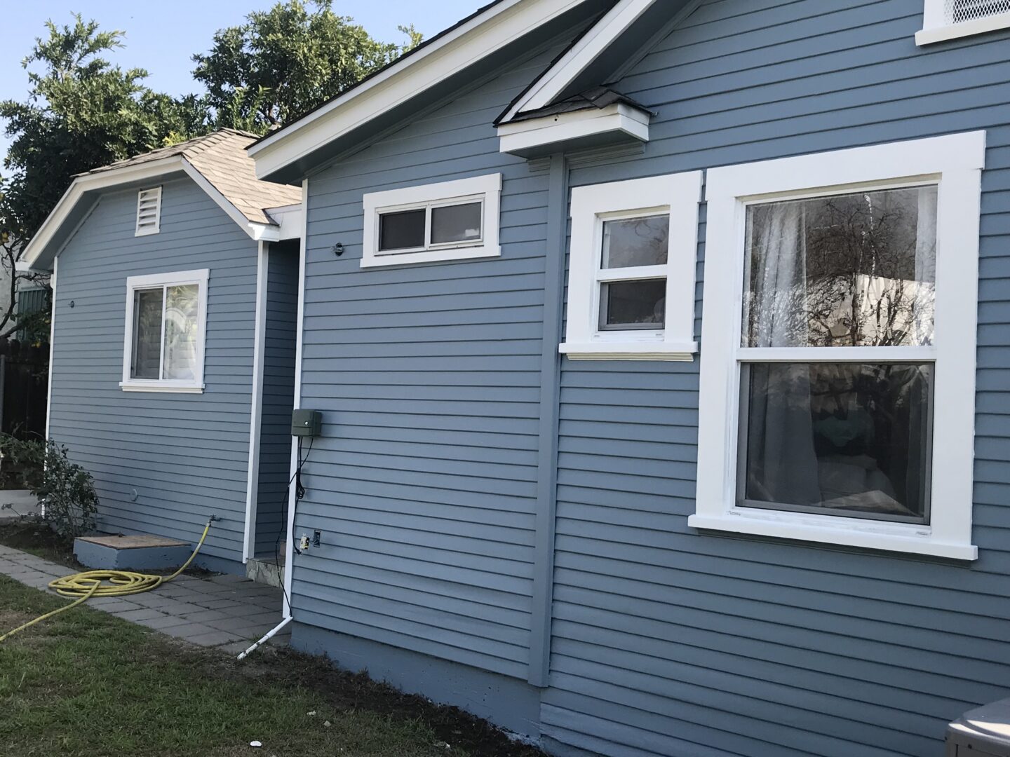 A blue house with white trim and windows.