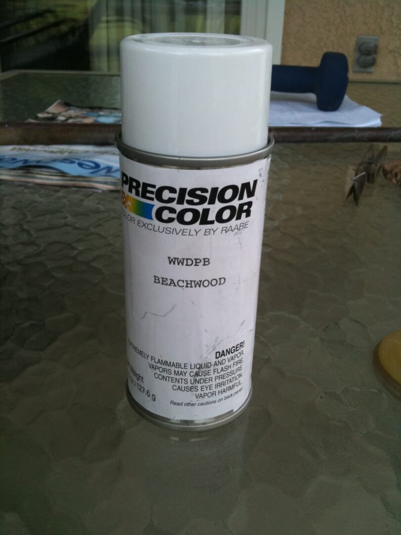 A spray can of paint sitting on top of a table.