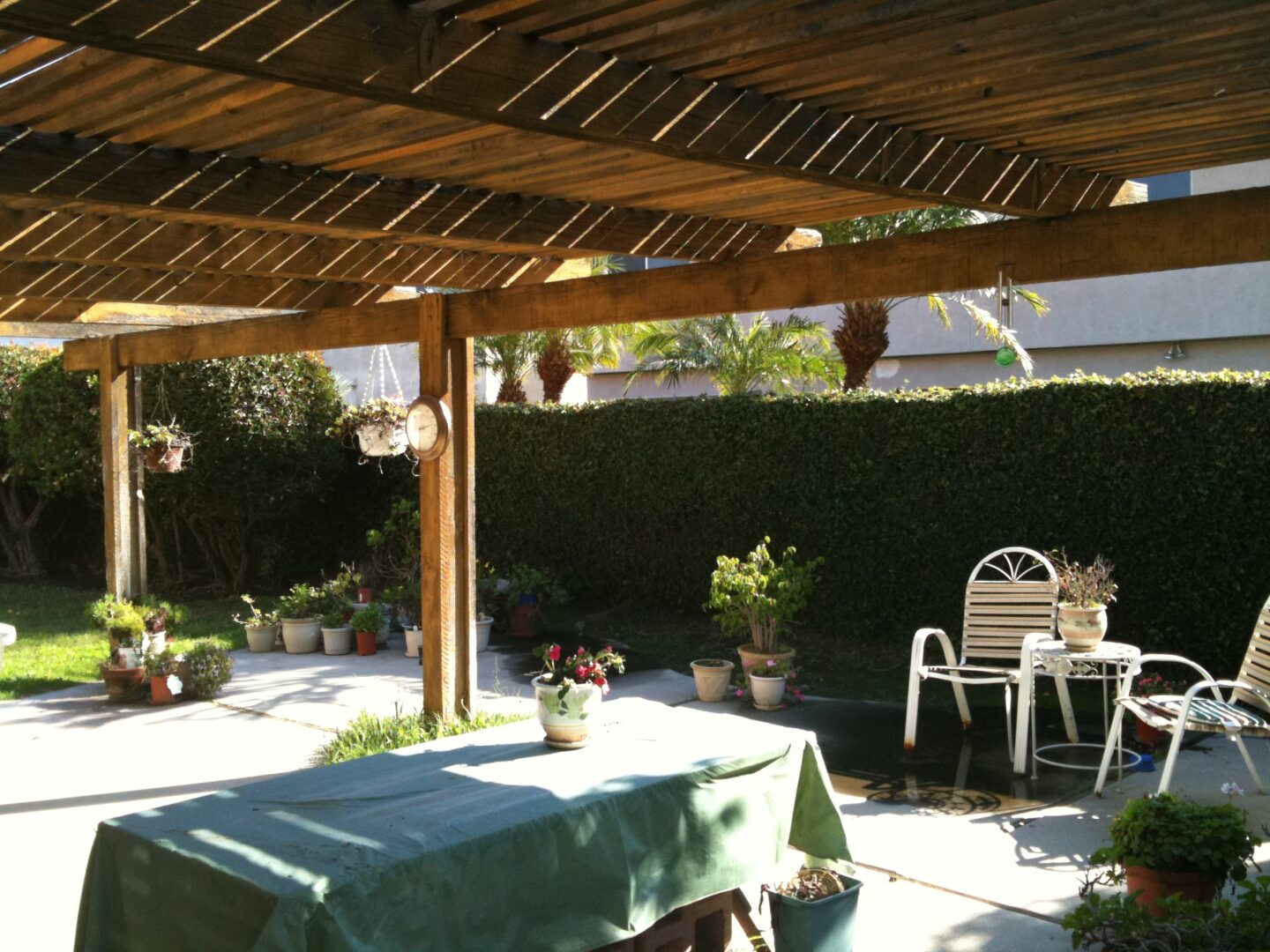 A table and chairs under an awning in the shade.