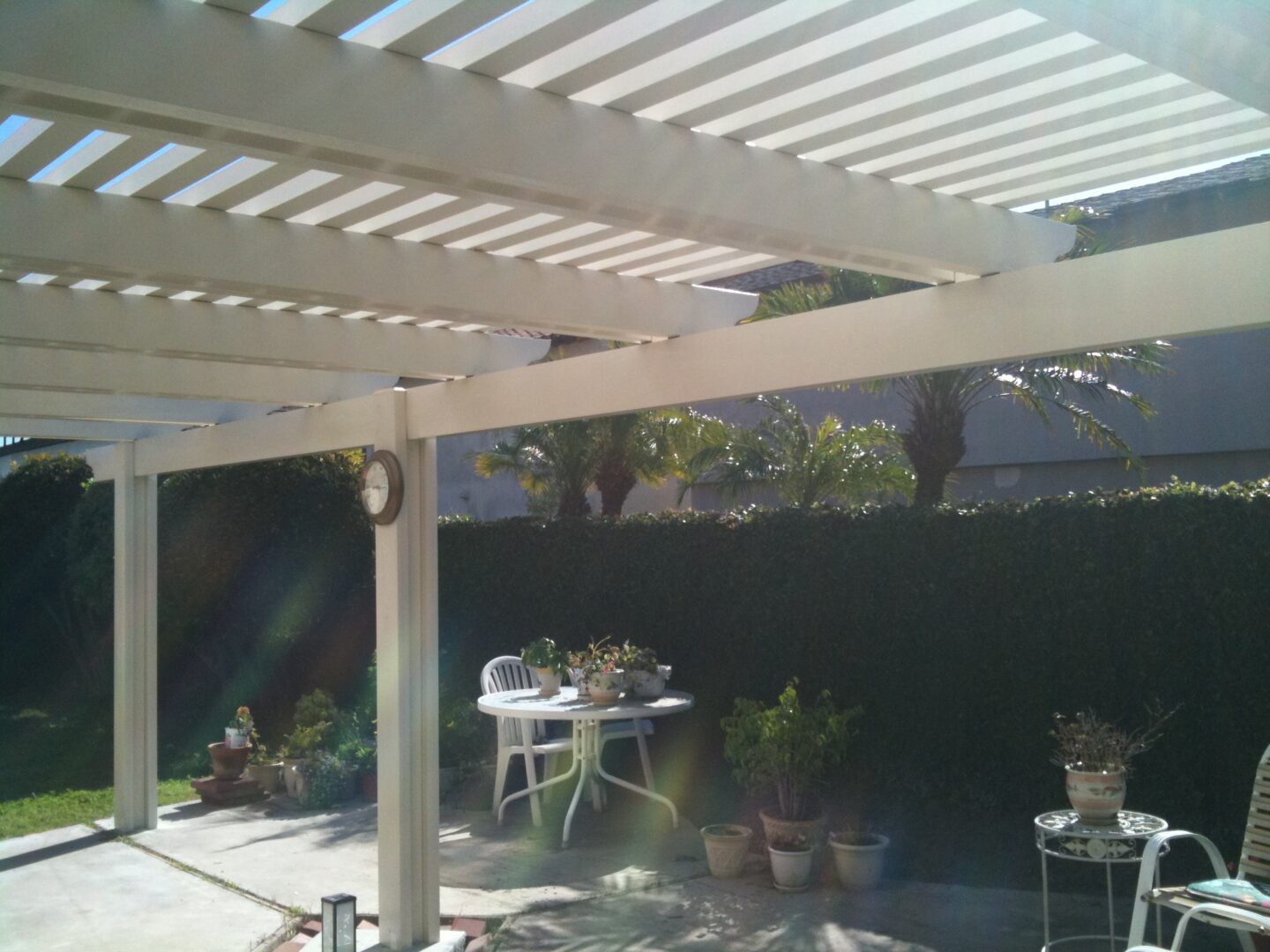 A patio with tables and chairs under an awning.