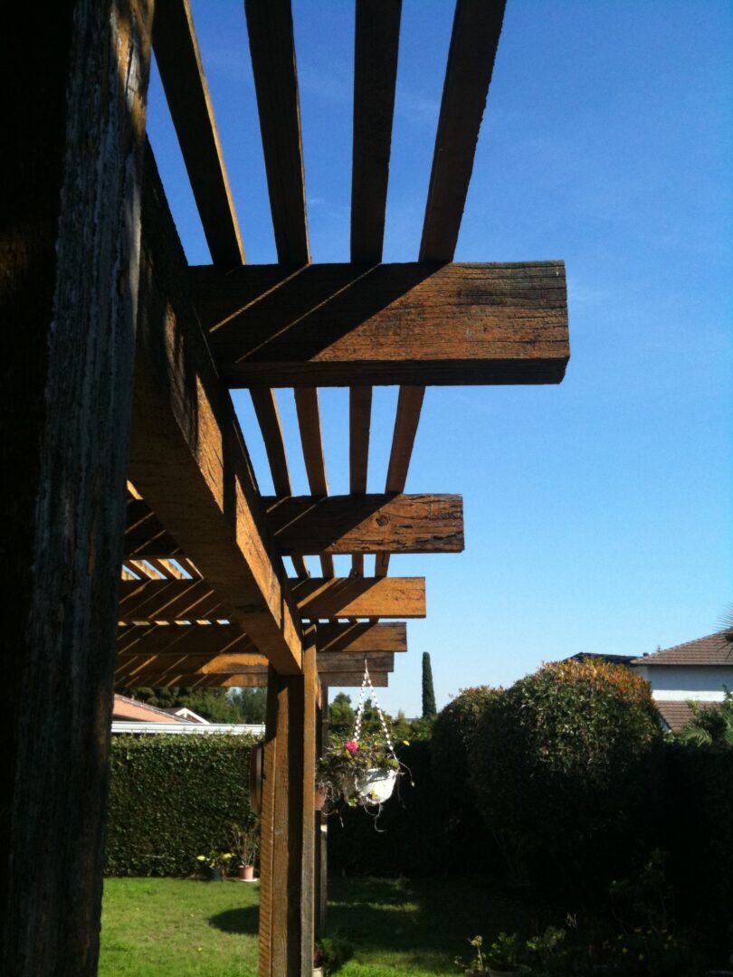 A wooden pergola with a blue sky in the background.