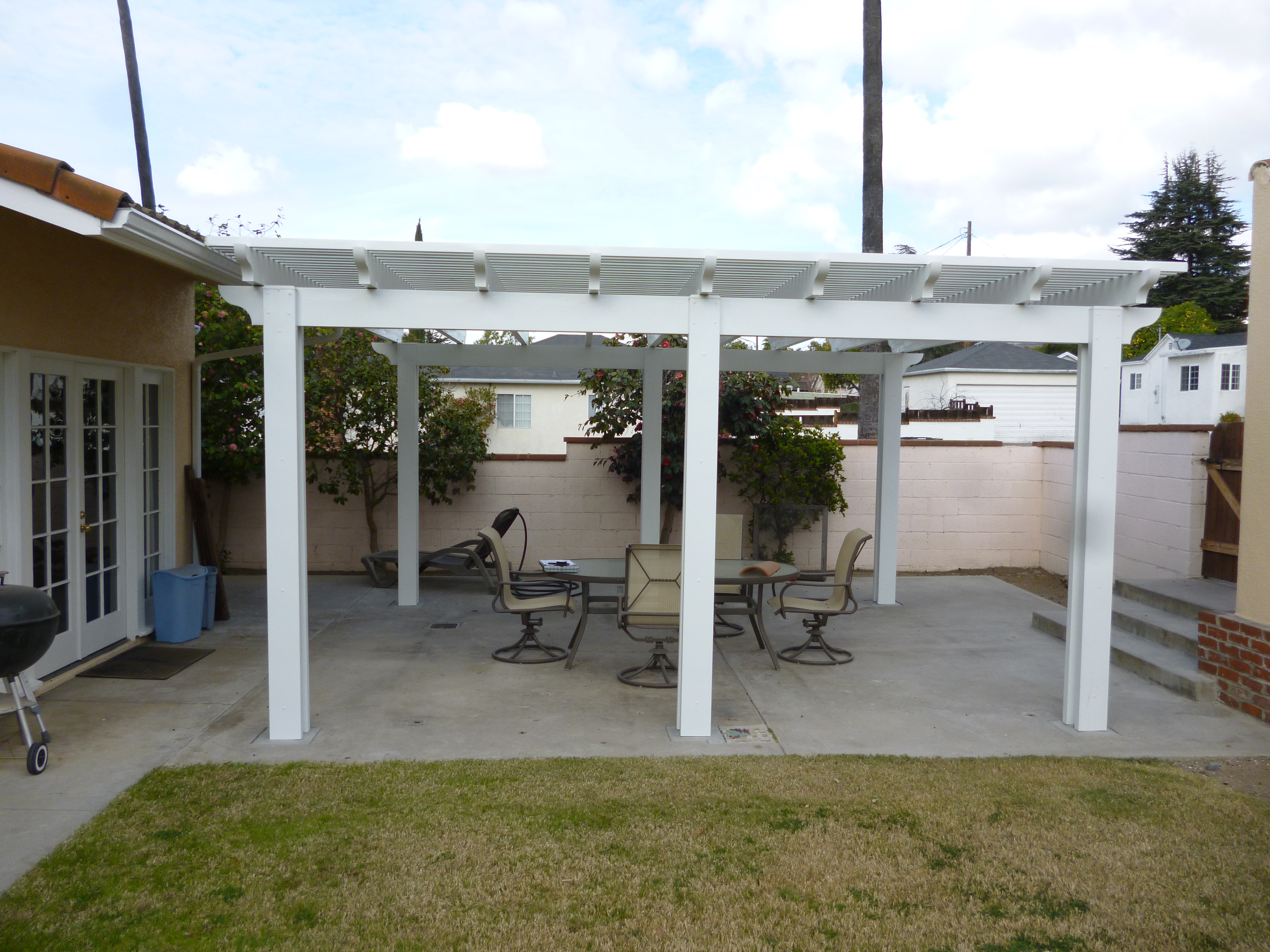 A patio with chairs and tables under an awning.