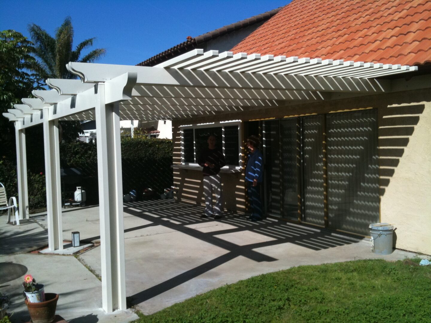 A patio cover with a grill and table in the middle.