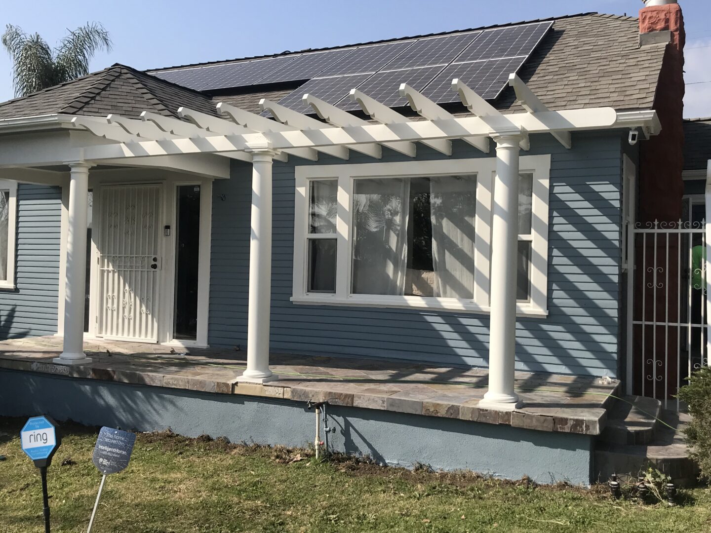 A house with a porch and roof that has been painted blue.