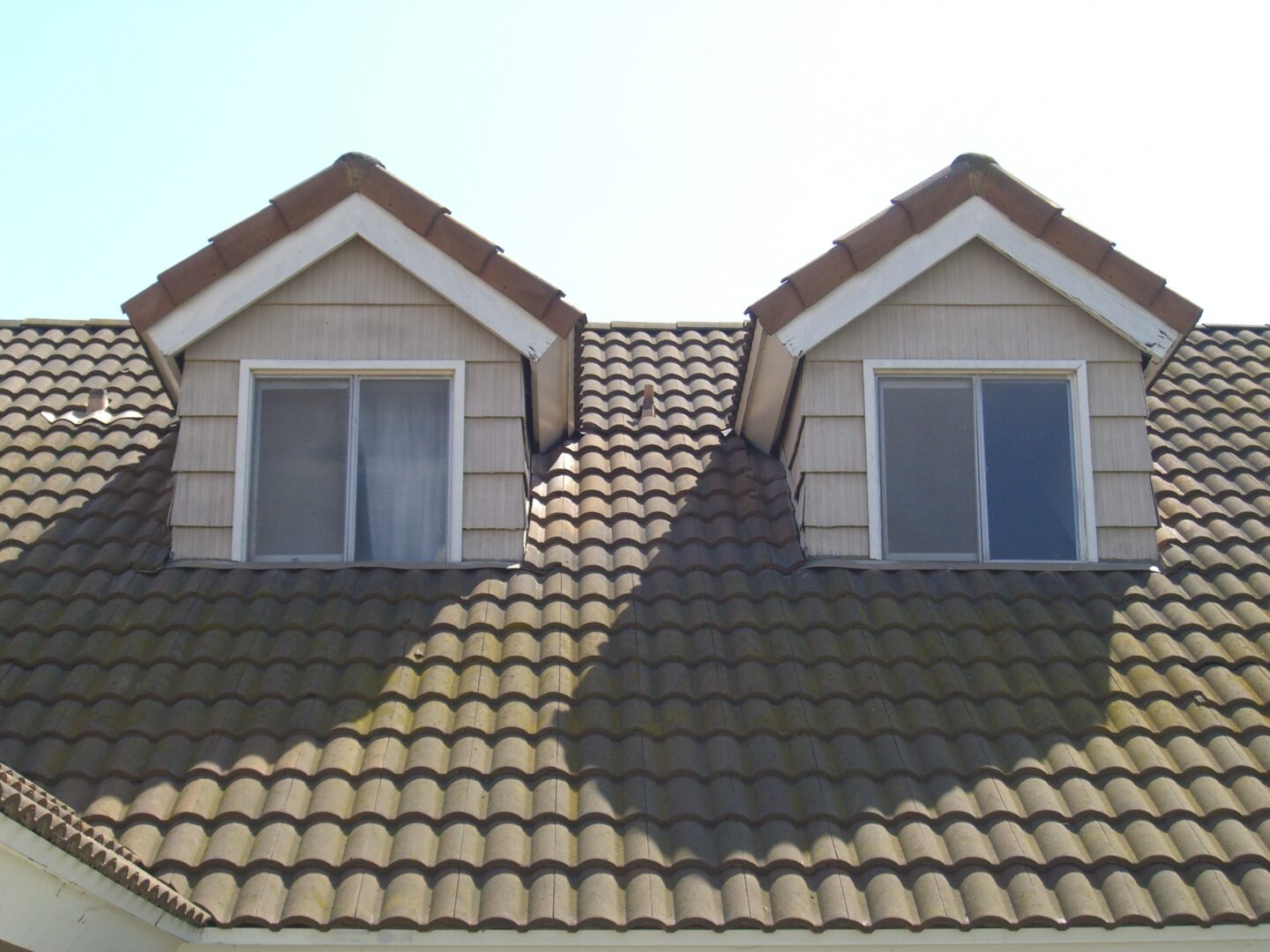 A roof with two windows and a tiled roof