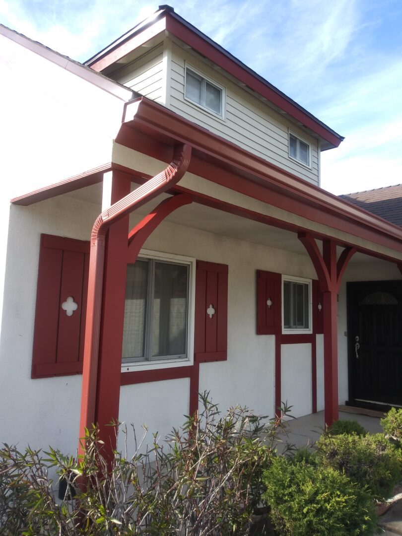 A house with red trim and white walls.