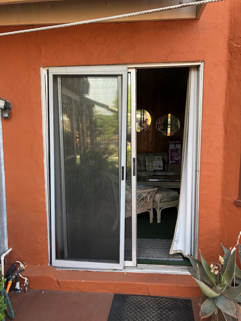 A sliding glass door with curtains open on the outside.