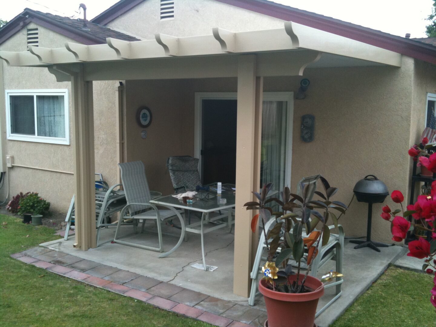 A patio with tables and chairs outside of the house.