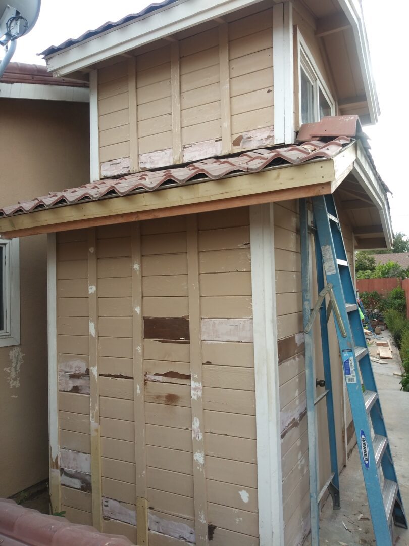 A building with some wood siding and a ladder