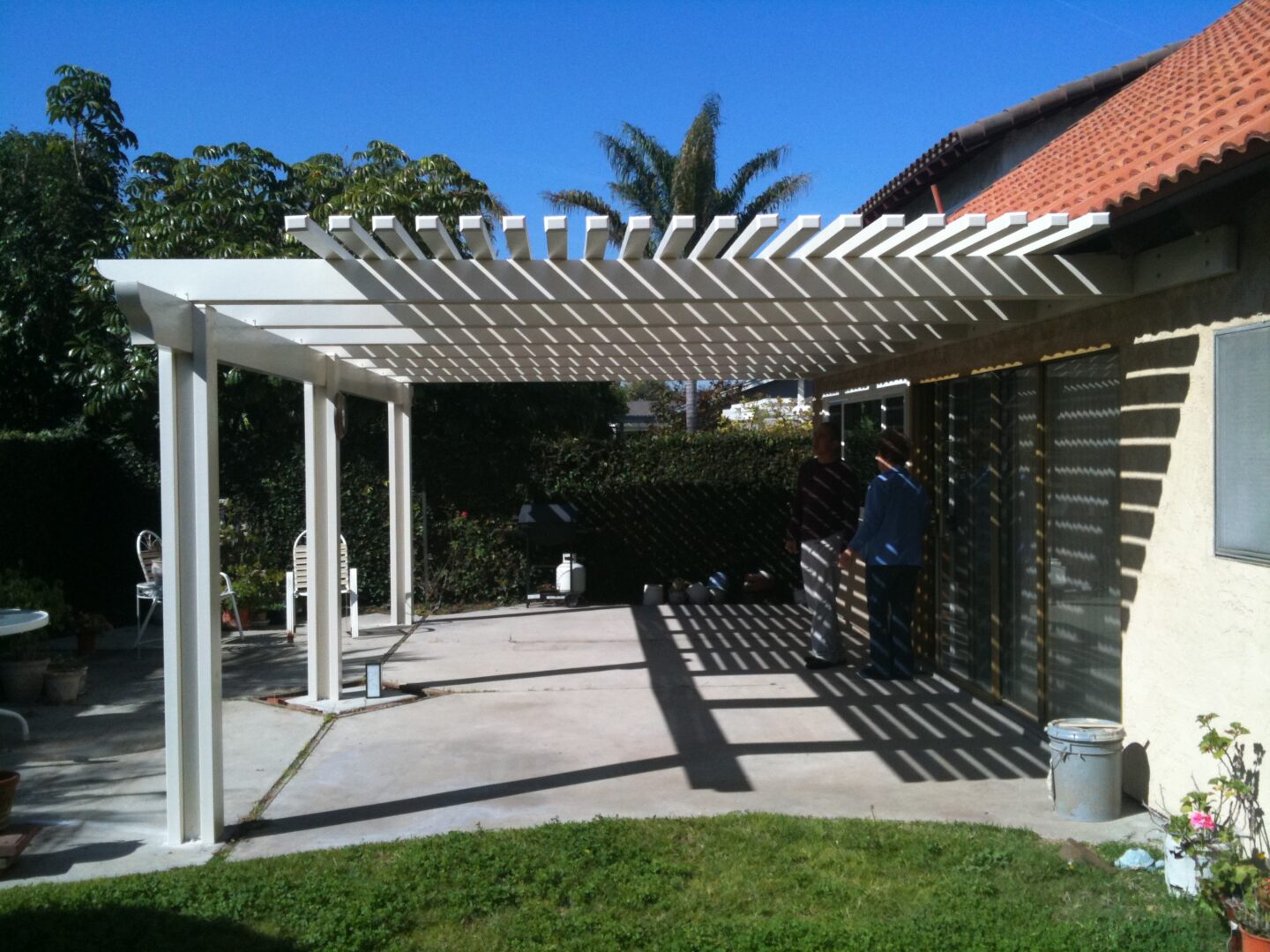 A patio with an open roof and a person standing on the side.