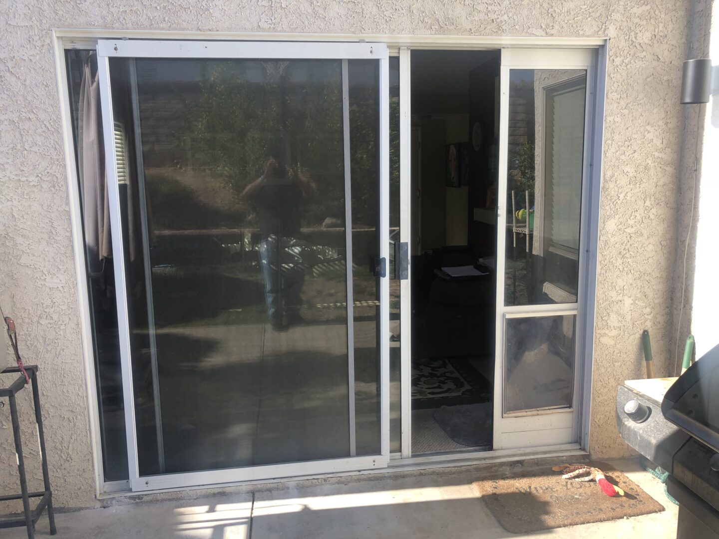 A sliding glass door with two windows and one window open.