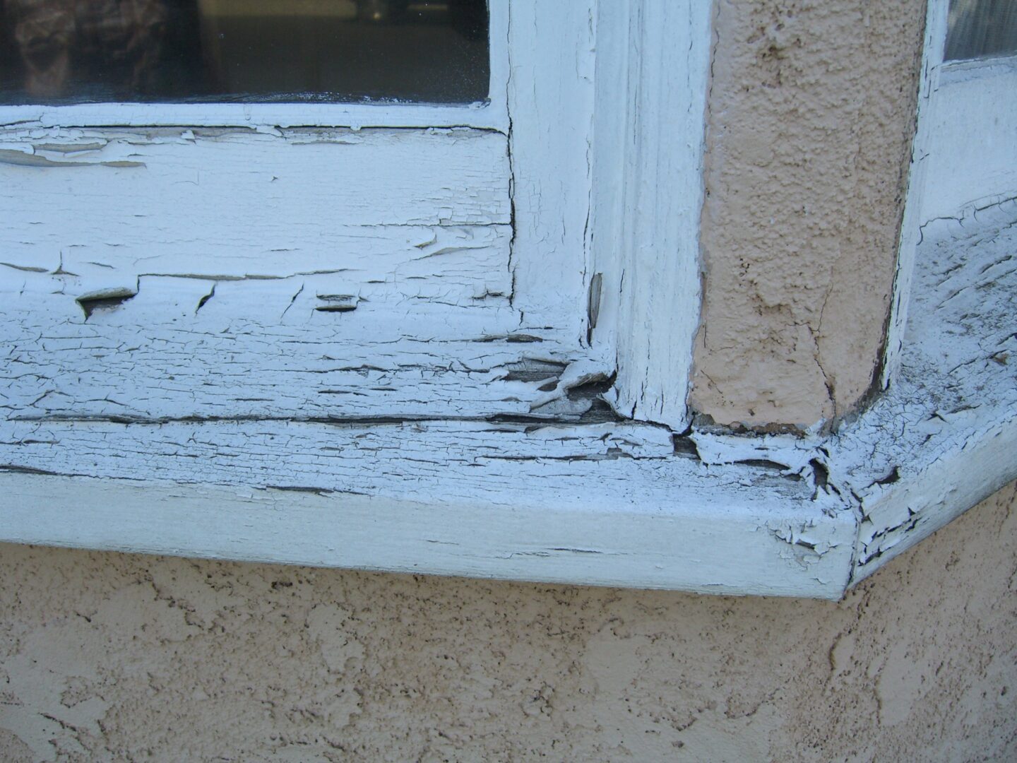 A window sill with peeling paint on it.