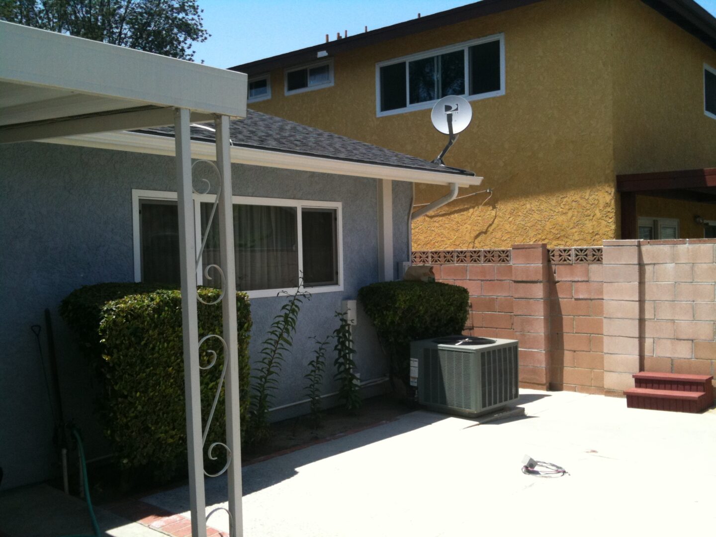 A back yard with a white awning and a building