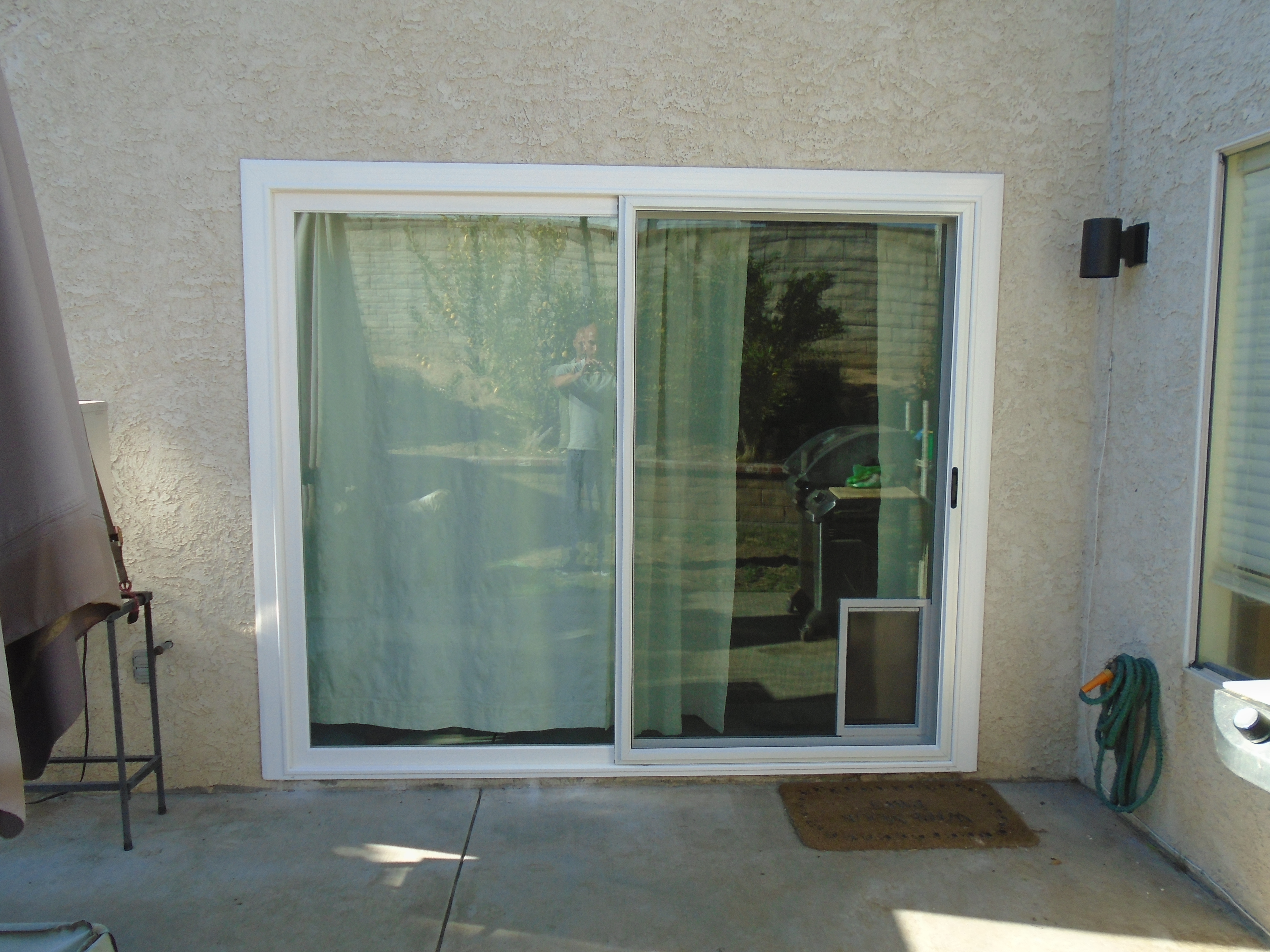 A sliding glass door with curtains on the outside.