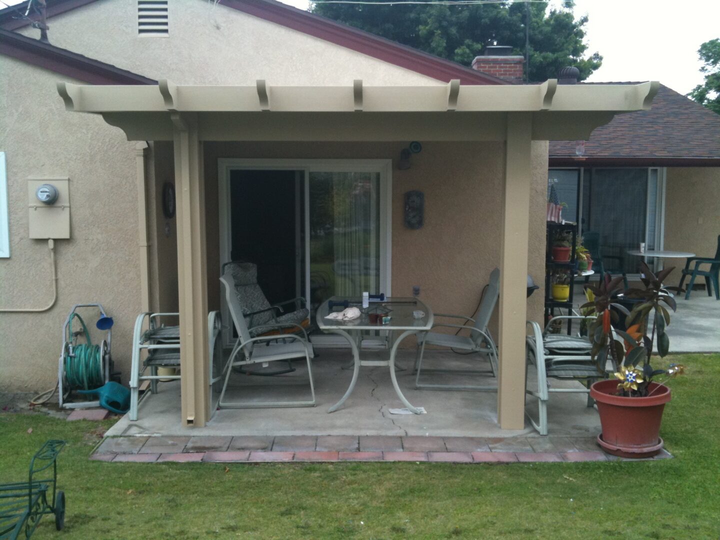 A patio with chairs and tables outside of the house.