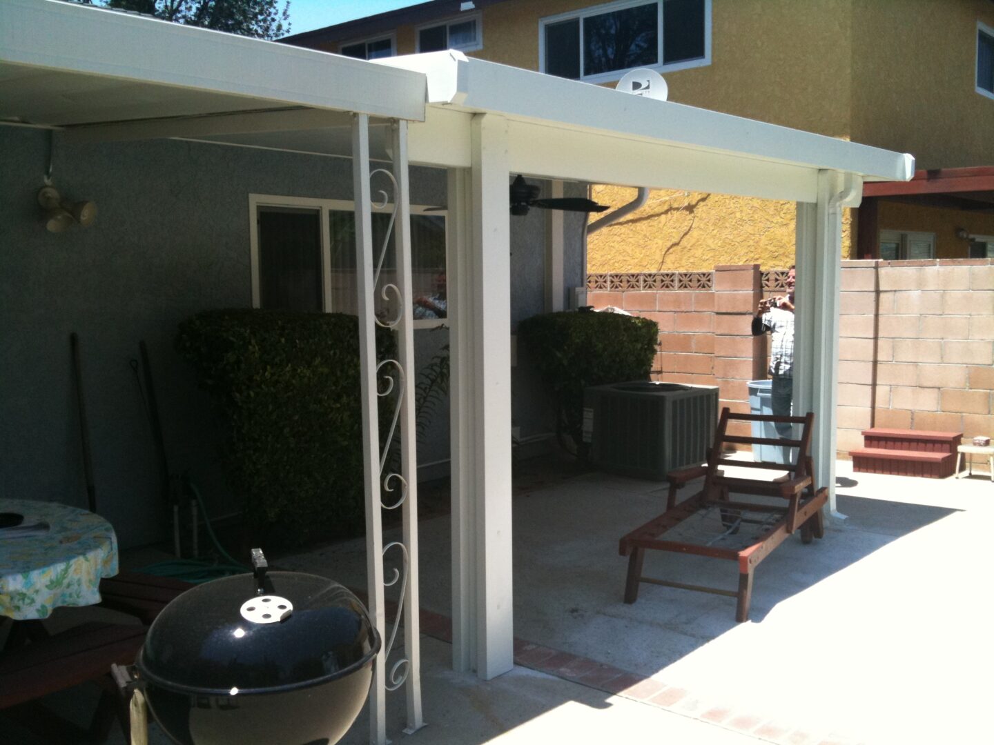 A patio with an open roof and chairs.