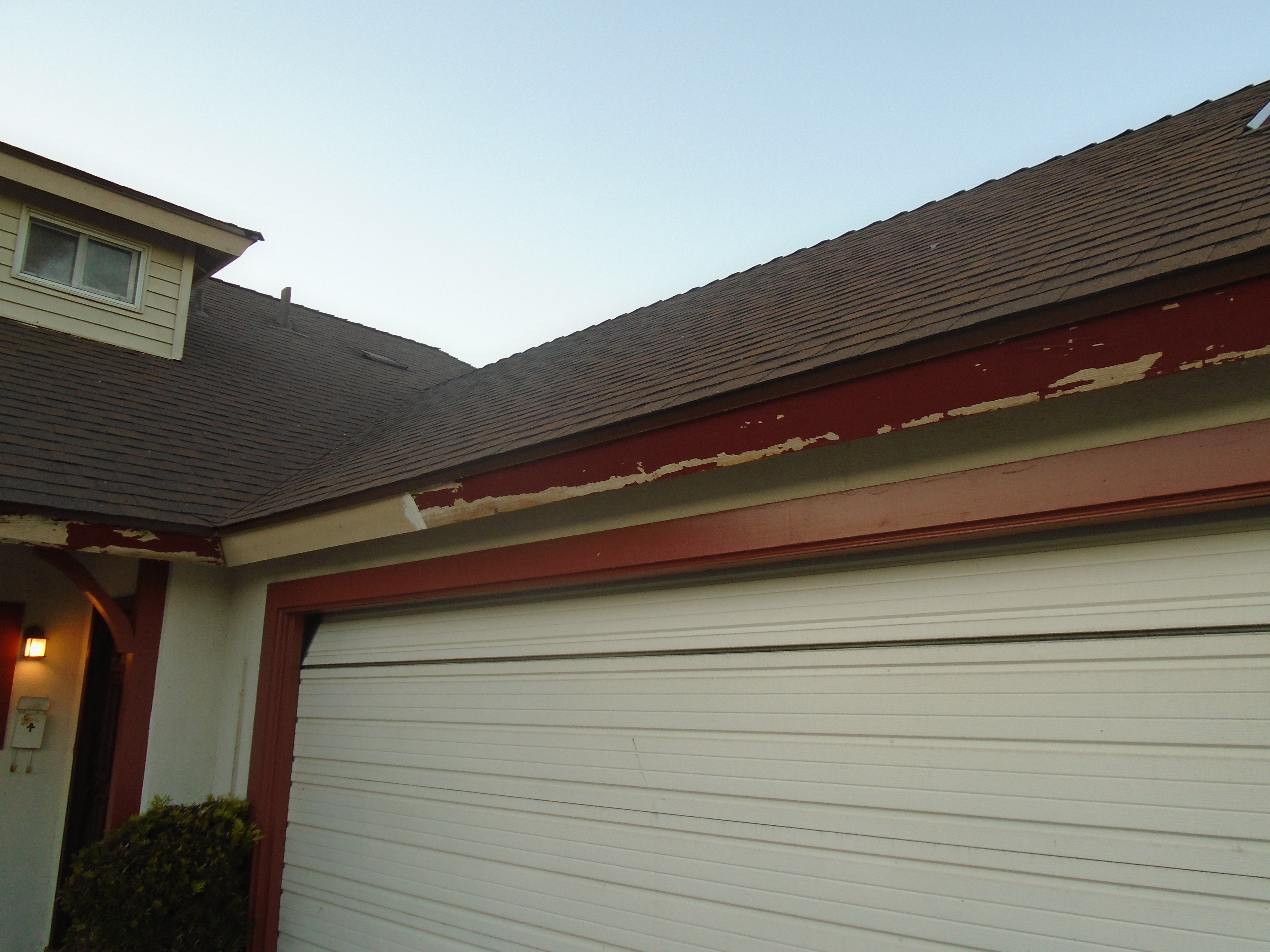 A garage door that is open and has some damage on it.