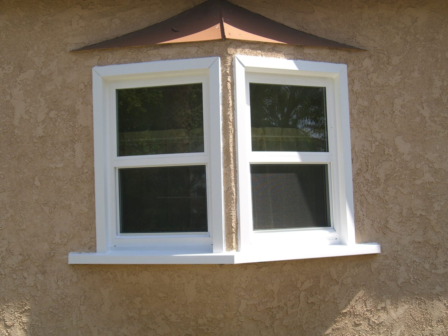 A window with two windows on the outside of a house.