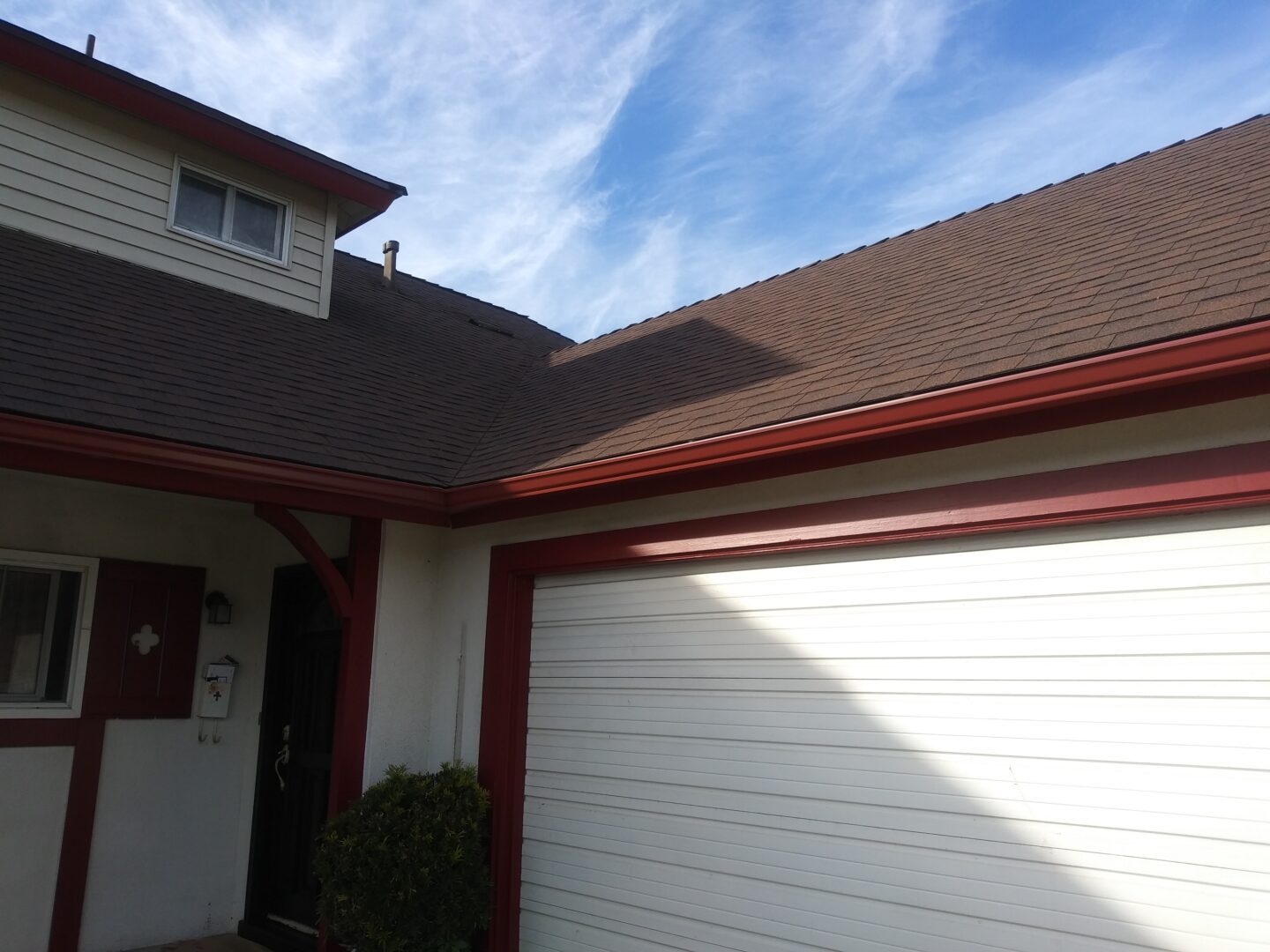 A house with a garage door and a roof.