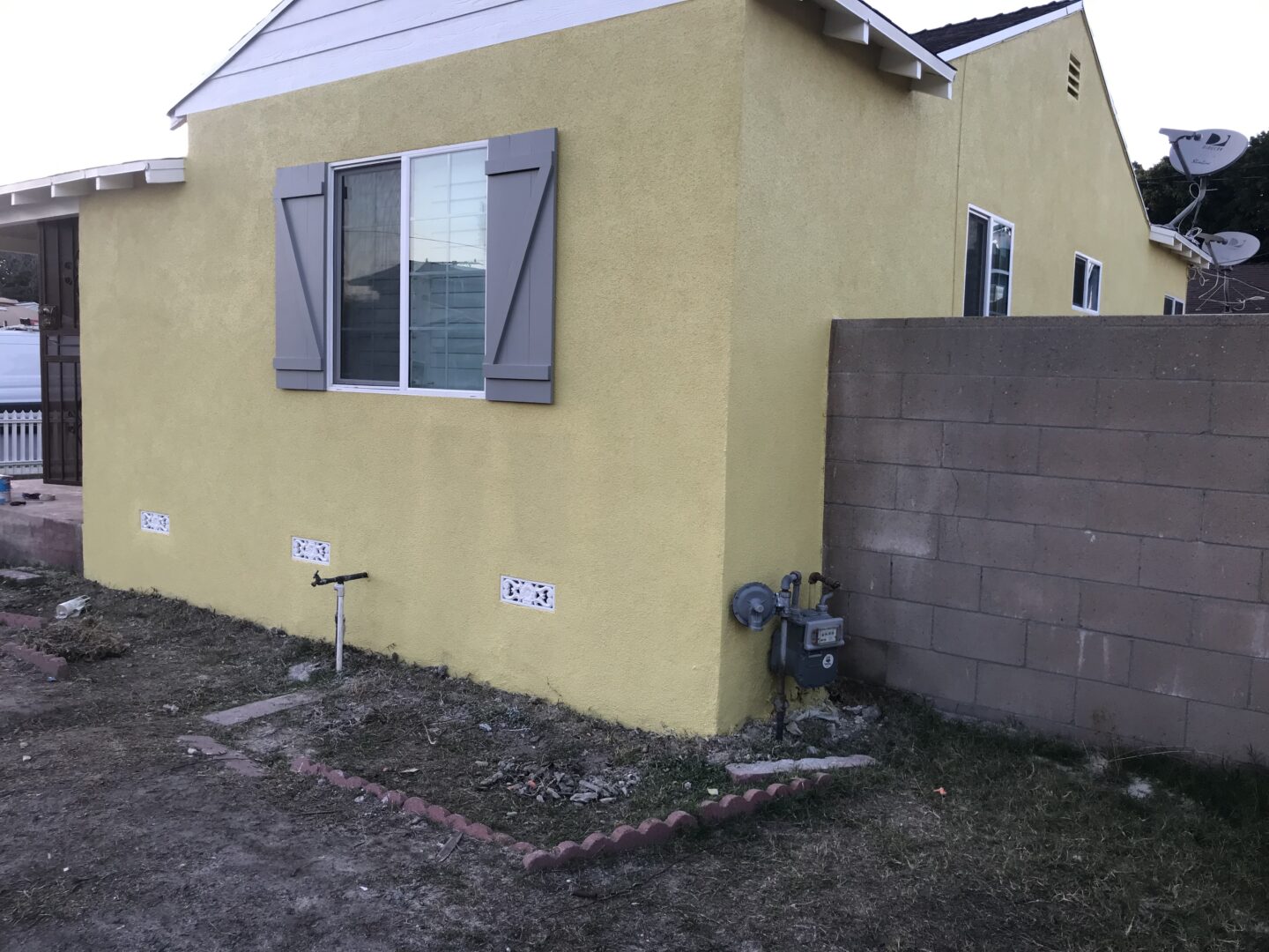 A yellow house with a fire hydrant in the corner.