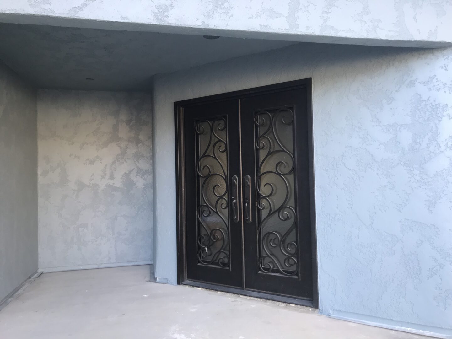 A pair of doors with decorative iron work on them.