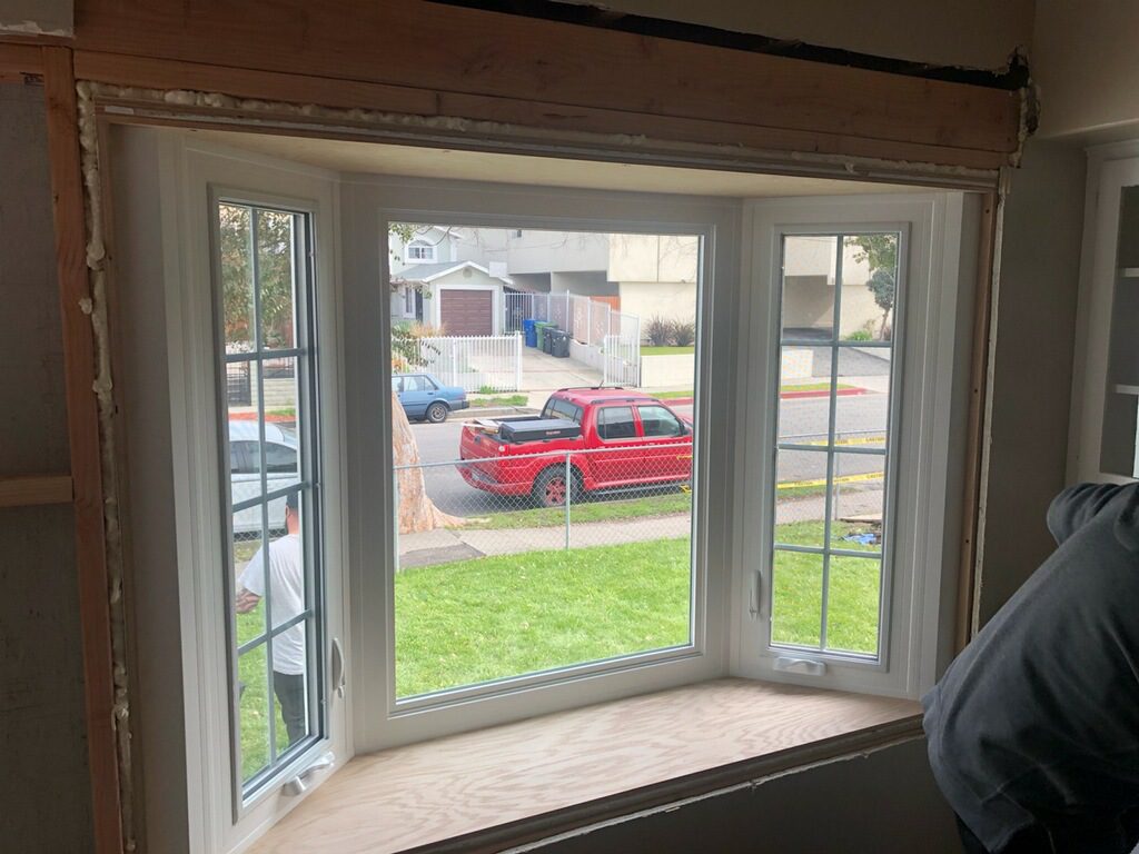 A red car is parked in the back of a house.