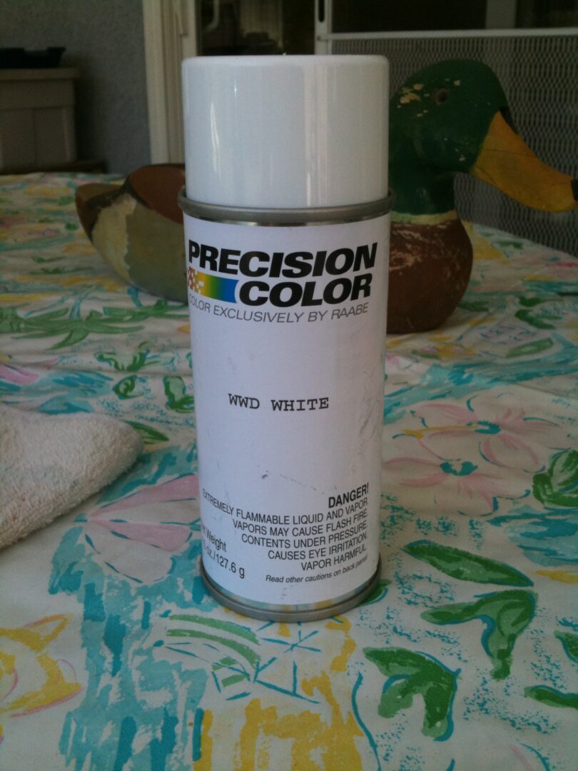 A spray can of paint on top of a table.