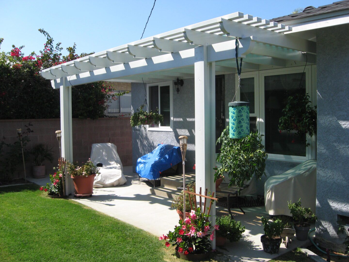 A patio with a covered area and lawn furniture.