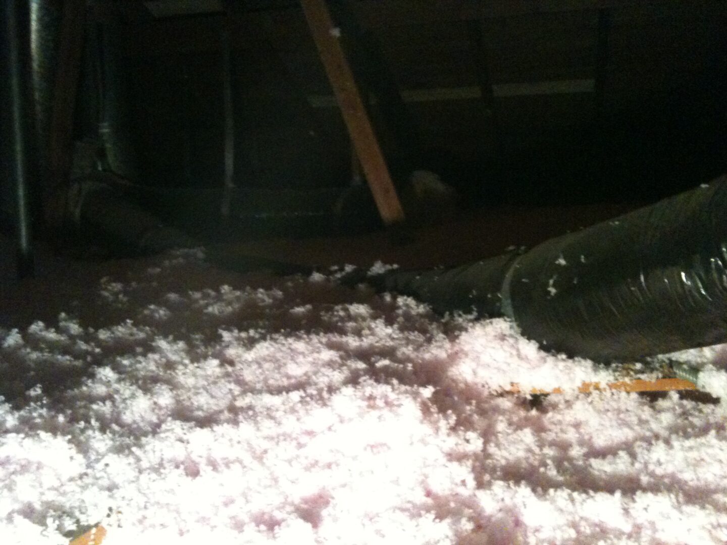 A pile of white foam in the middle of an attic.