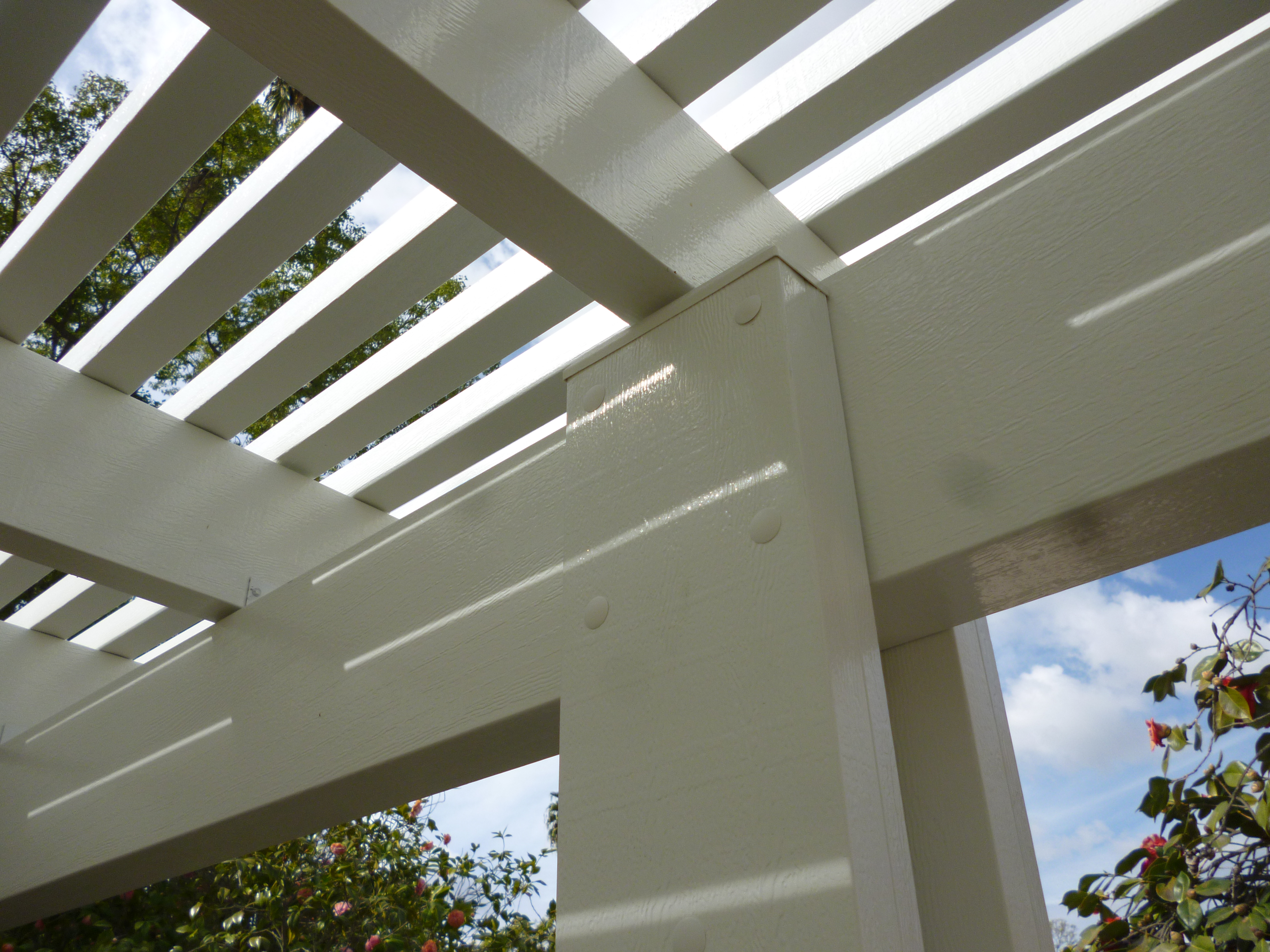 A white pergola with a sky background